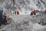 Работники коммунальных бригад сооружают дамбы и вручную очищают дождеприемники от снежных масс